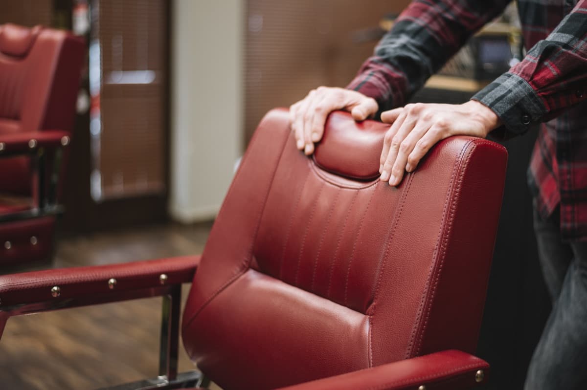 Craftsperson restoring a red leather chair