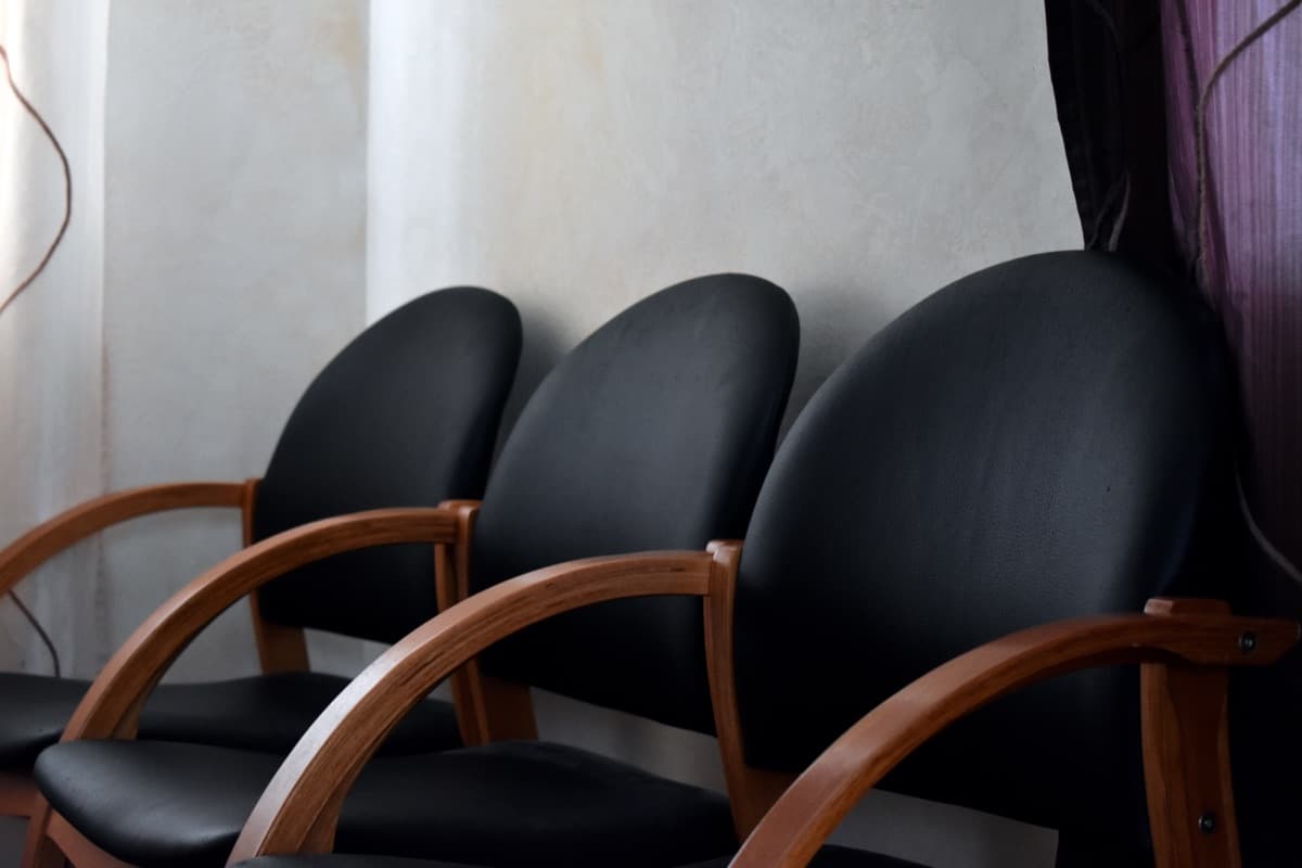 Three black chairs with curved wooden armrests