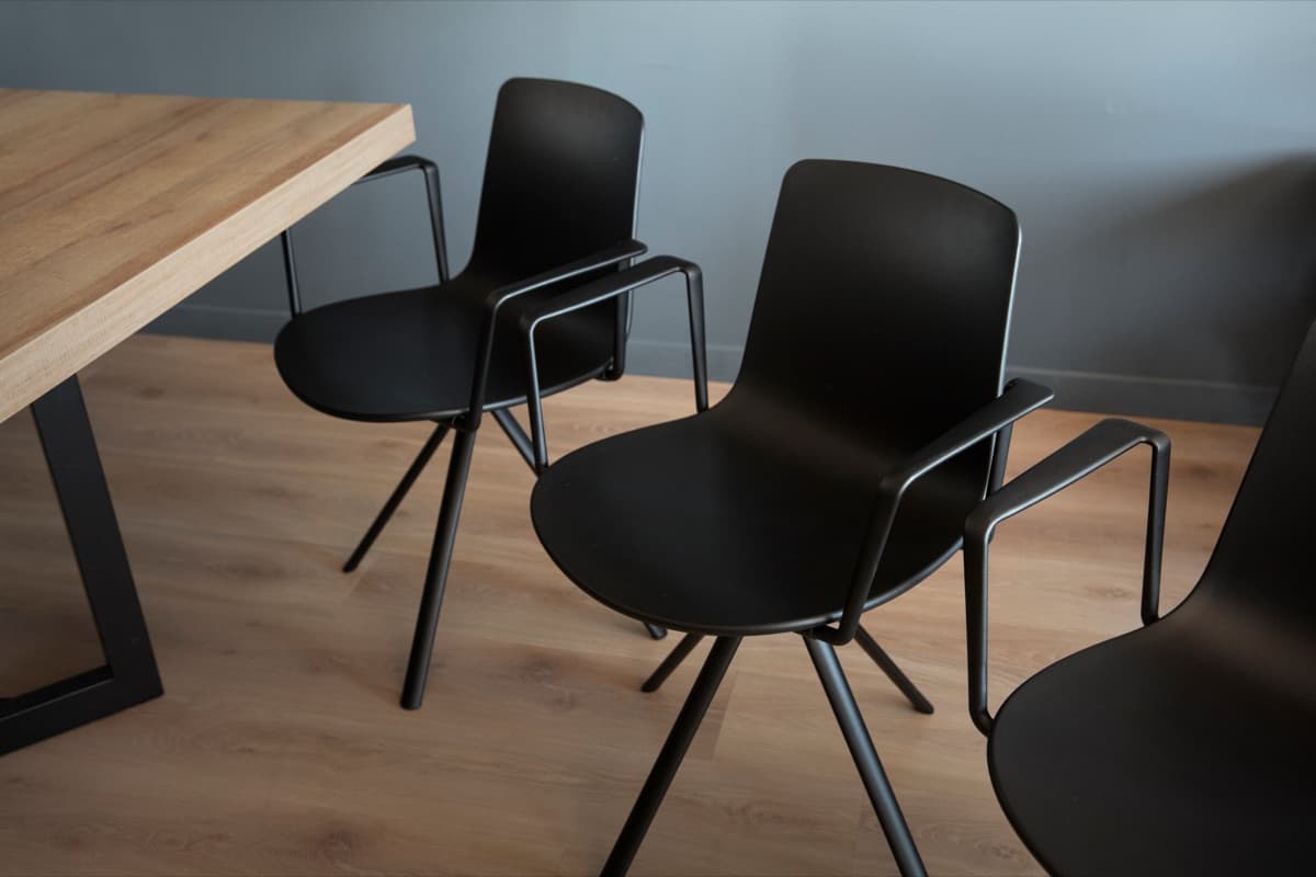 Black meeting chairs arranged beside a wooden table